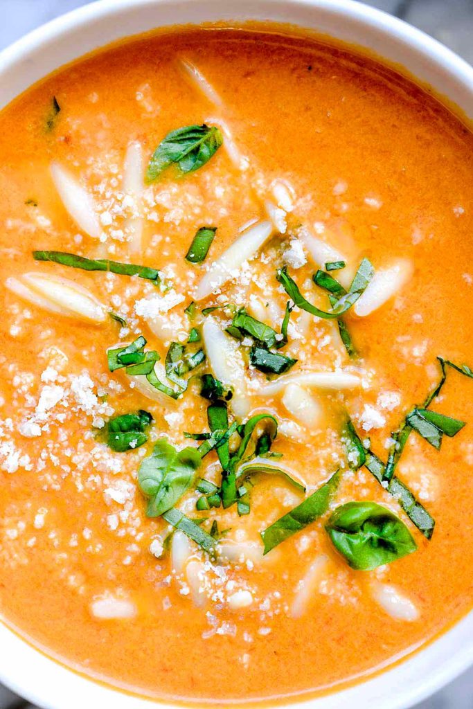 bowl of tomato basil soup topped with Parmesan and basil