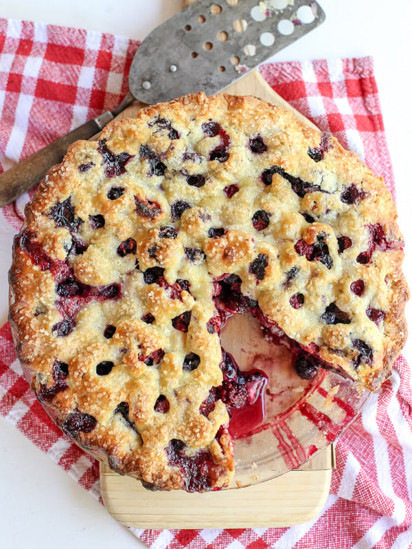sliced mixed berry pie on red gingham hand towel