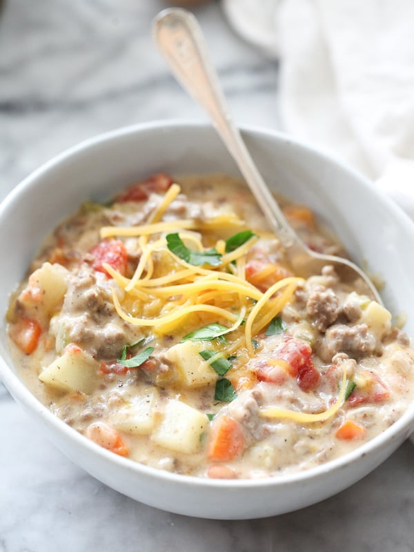 bowl of homemade cheeseburger soup topped with cheese and parsley