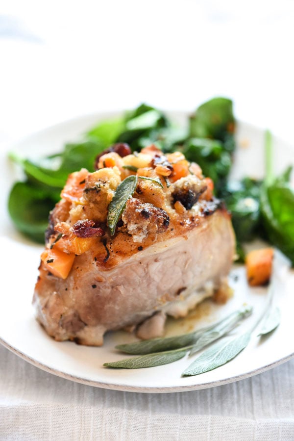 stuffed pork chop on white plate with fresh sage leaves