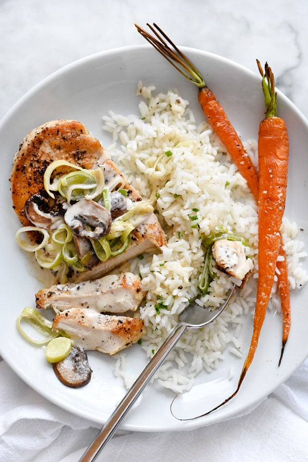 creamy mushroom chicken on white plate with rice and carrots
