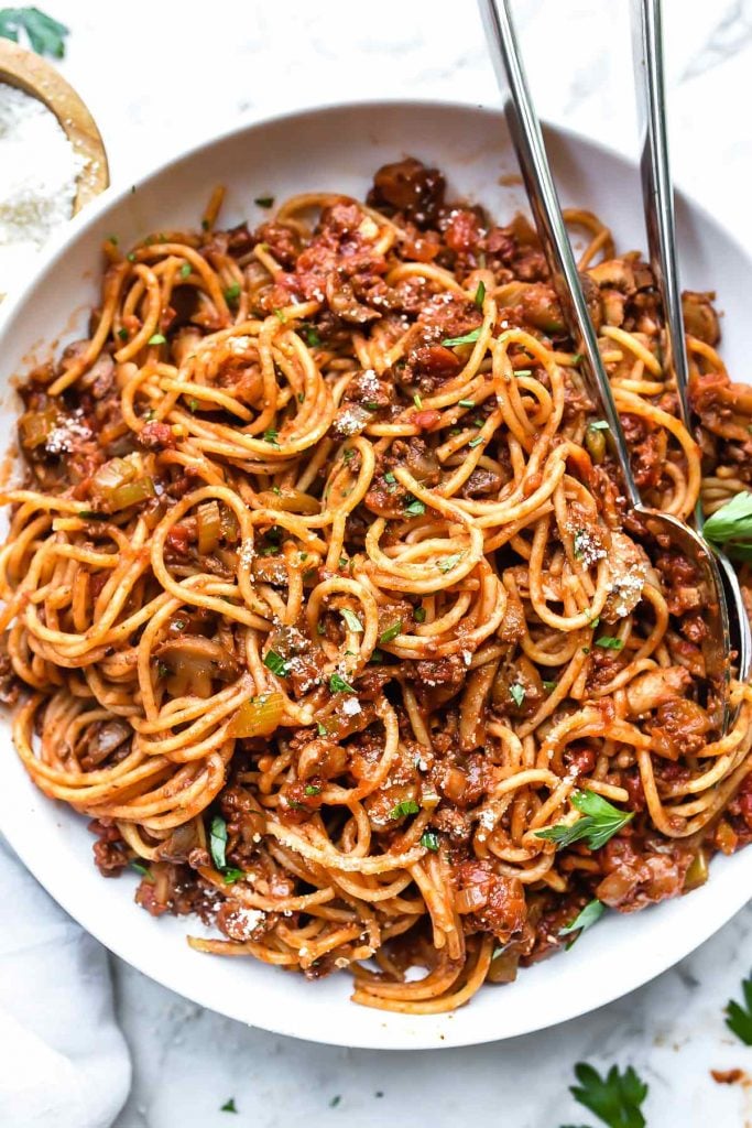 spaghetti and homemade pasta sauce on white plate with forks