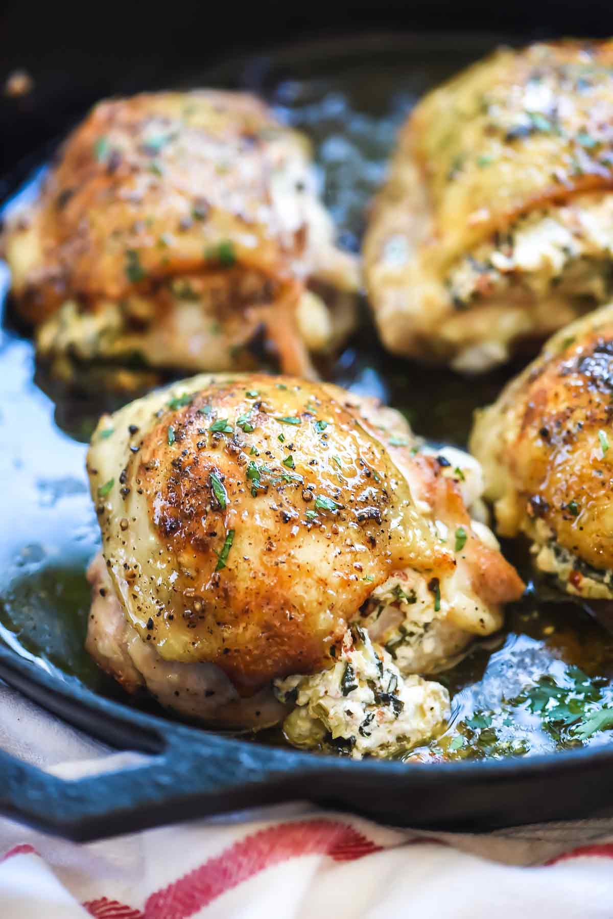 Stuffed Chicken Thighs with Spinach and Goat Cheese is the best 30-minute, cast iron chicken recipe thanks to it's cheesy center and crispy skin | foodiecrush.com #chicken #dinner #recipe #foodblogger #spinach #cheese
