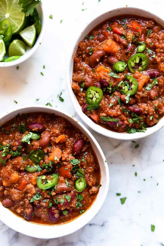 two white bowls filled with crockpot turkey chili
