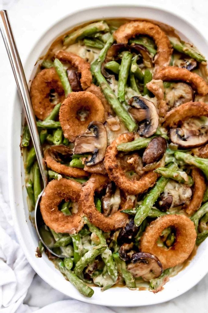 green bean casserole with onion rings in white baking dish