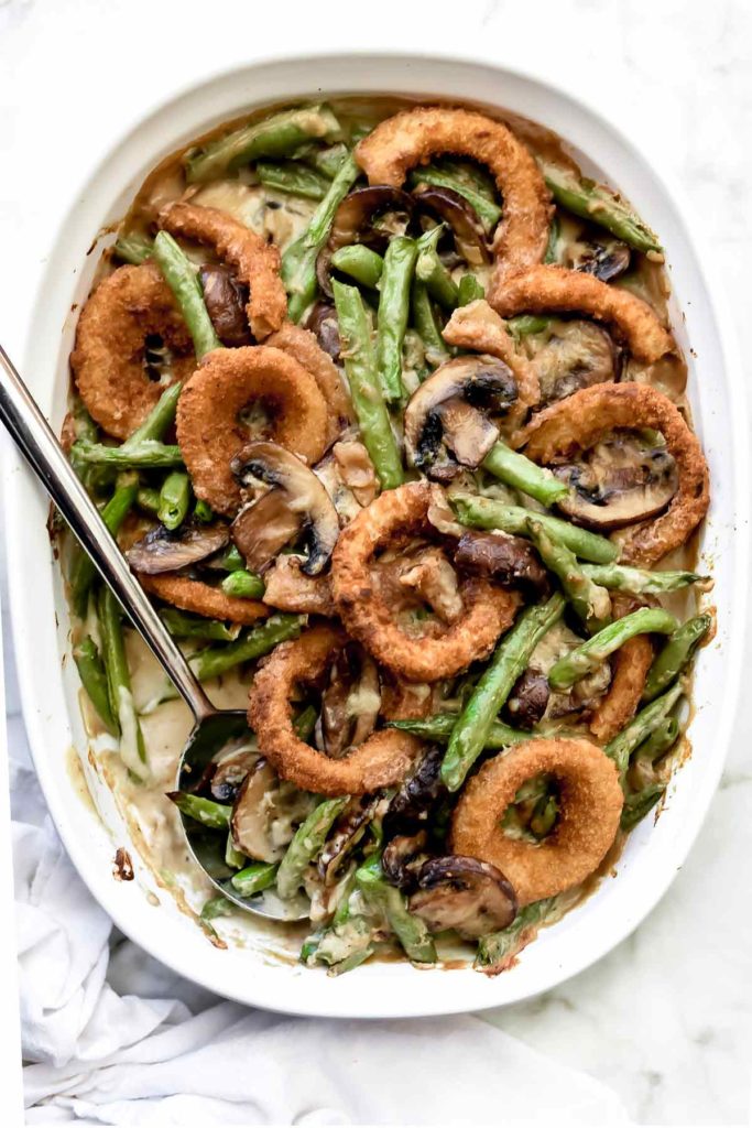 homemade green bean casserole in white baking dish with spoon