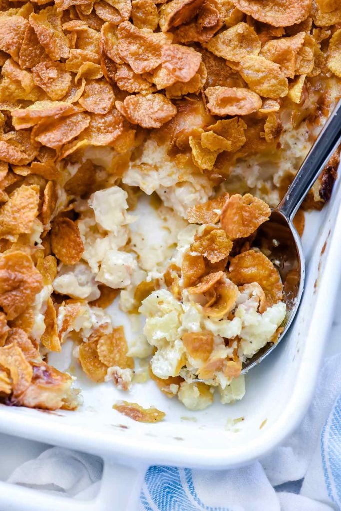 Funeral potatoes in baking dish with spoon