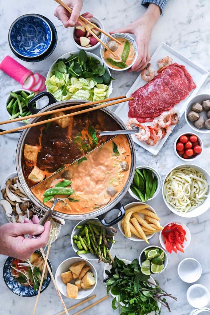 Red Curry Hot Pot at Home - Asian Recipes - 6 assortment of hot pot broths, vegetables, and proteins on marble counter