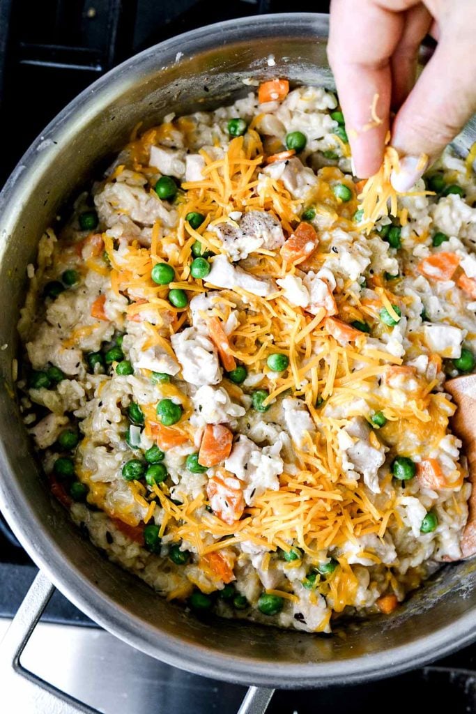 topping easy chicken and rice casserole with shredded cheese
