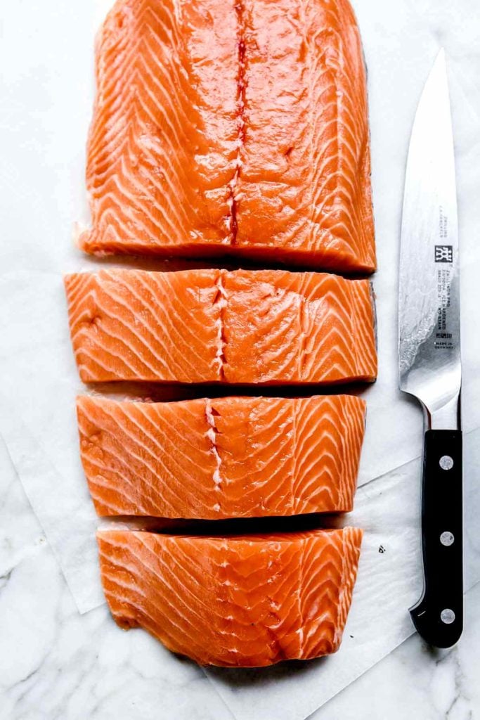 A large salmon fillet sliced into smaller fillets 
