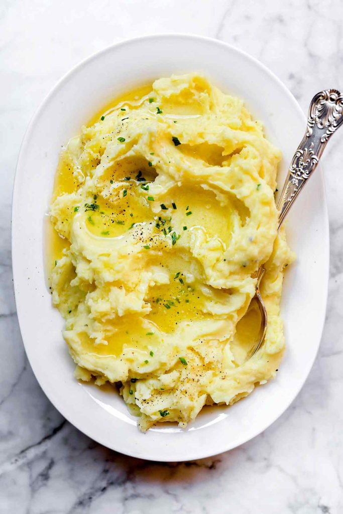 easy mashed potatoes in white serving dish with spoon