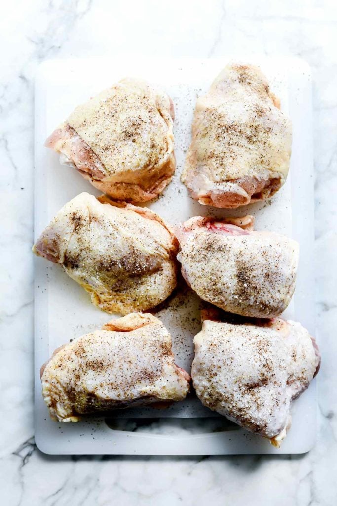 Chicken Thighs with Salt and Pepper on Cutting Board | foodiecrush.com