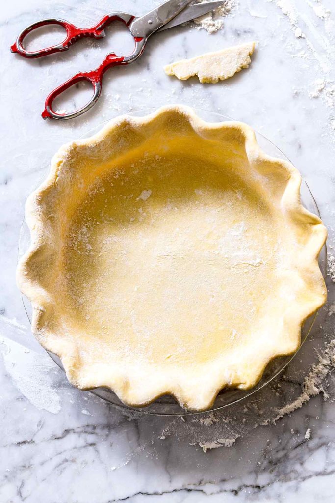crimped butter pie crust in glass pie plate