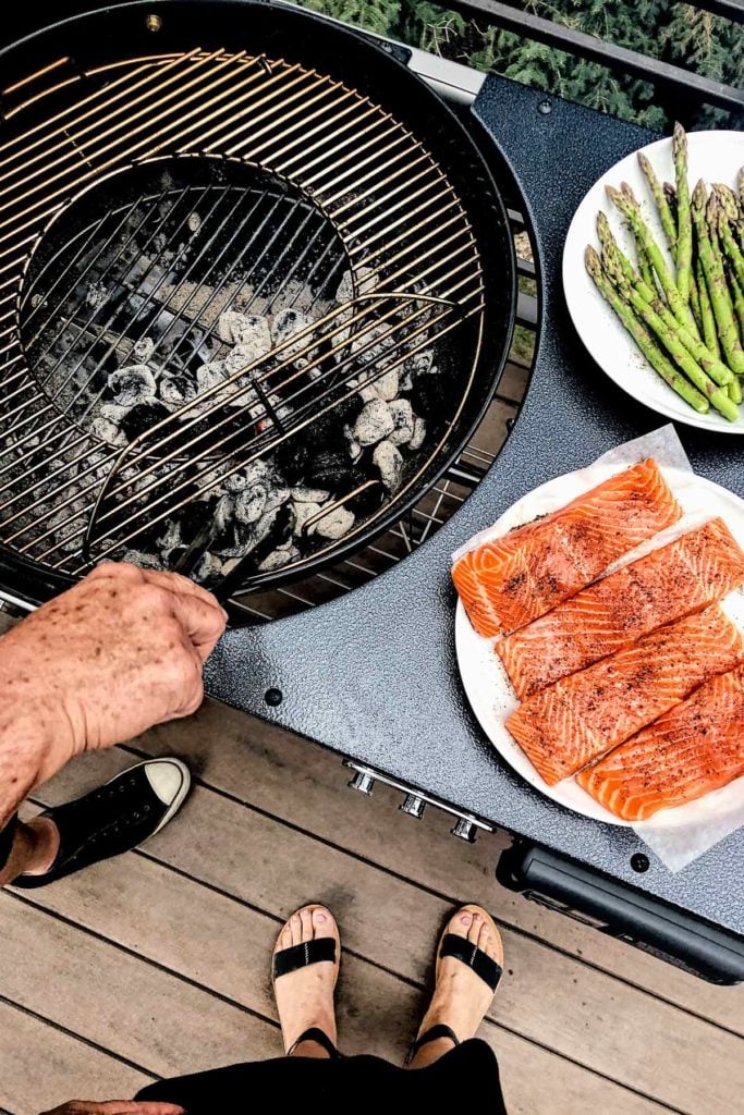 An overhead view of a charcoal grill being prepped to grill salmon