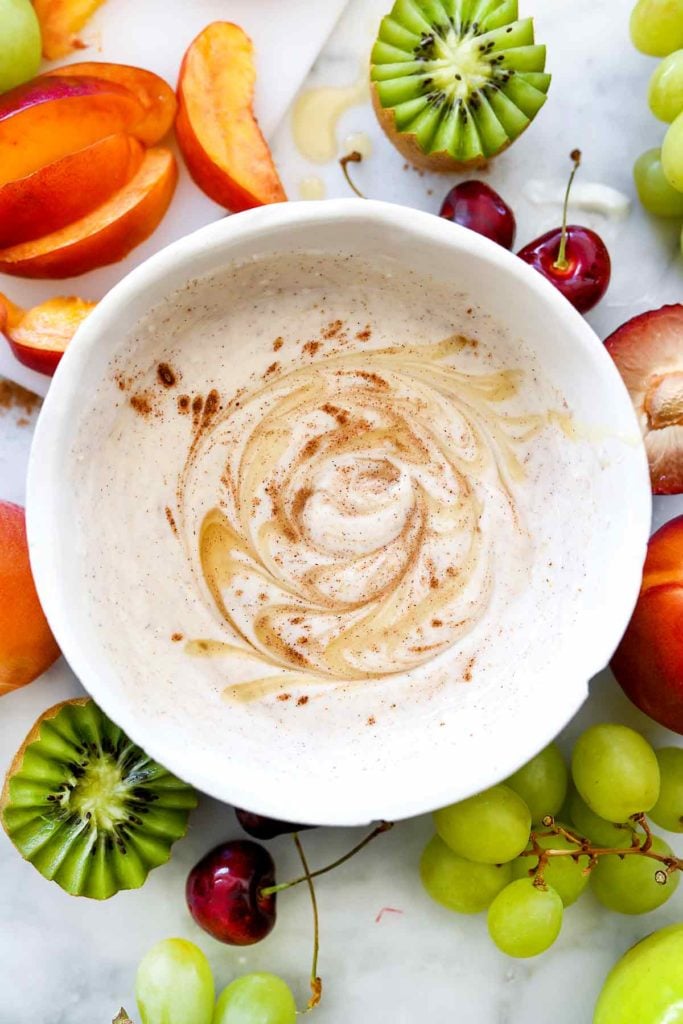 healthy fruit dip swirled with cinnamon and honey in white bowl