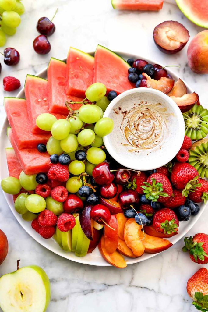platter of fresh fruit with bowl of fruit dip in the center