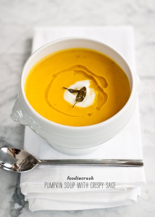 bowl of pumpkin soup garnished with mascarpone and sage leaves