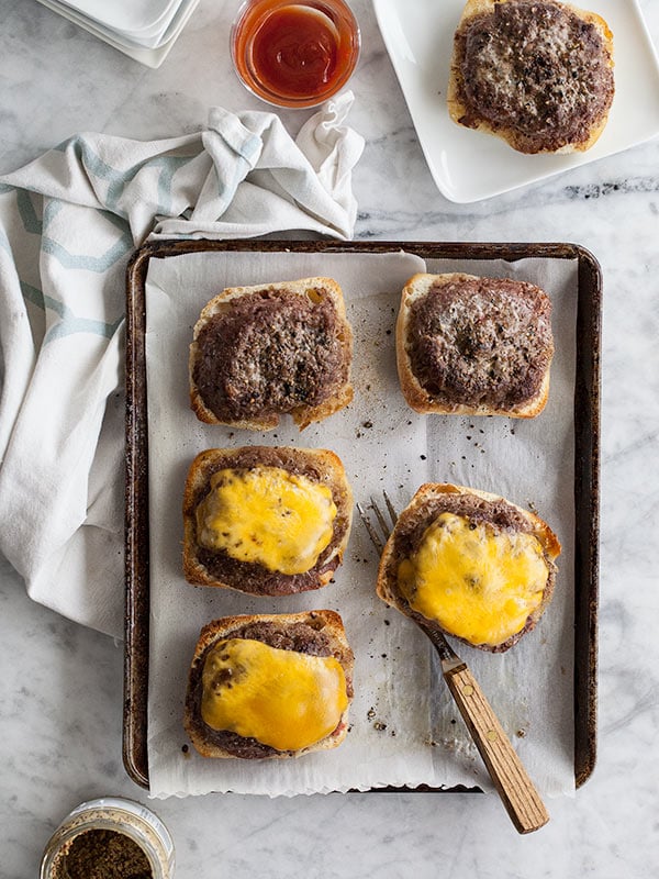 open faced baked hamburgers topped with cheddar cheese