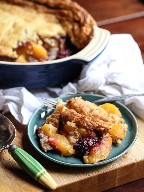 Peach and Blackberry Cobbler on plate in front of baking dish
