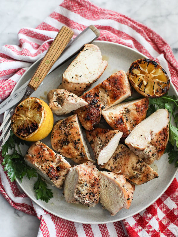 sliced grilled chicken breasts on white plate