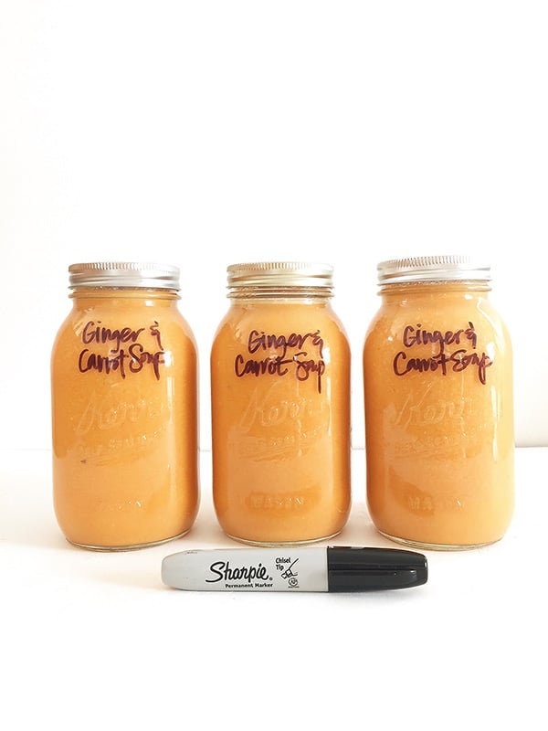 three jars filled with carrot ginger soup
