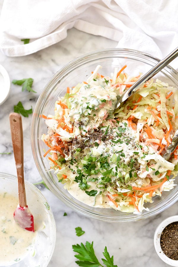 mixing together easy coleslaw in large glass bowl
