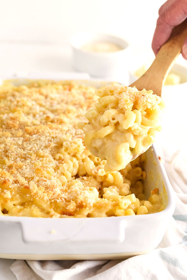 serving homemade mac and cheese with wooden spoon