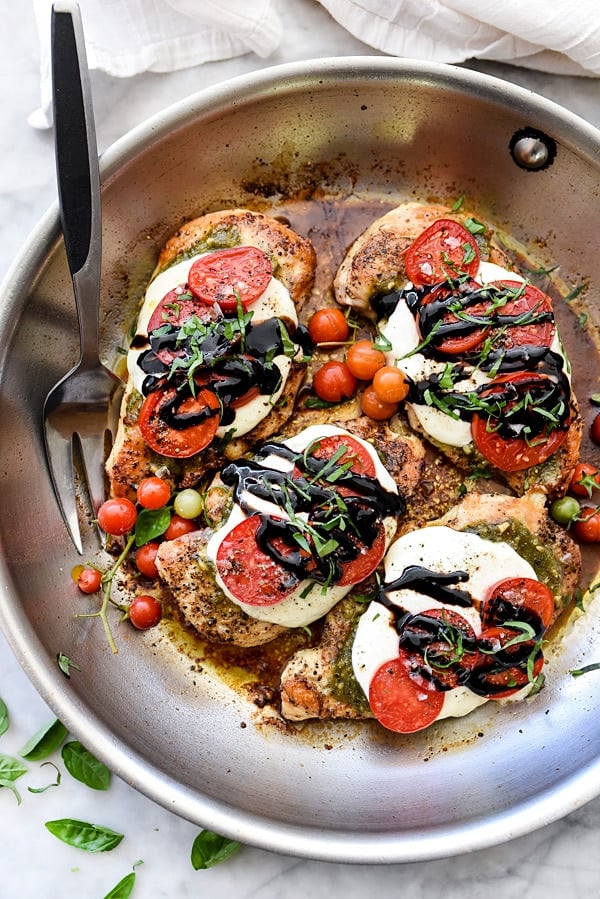 Overhead view of caprese chicken breasts in a skillet 