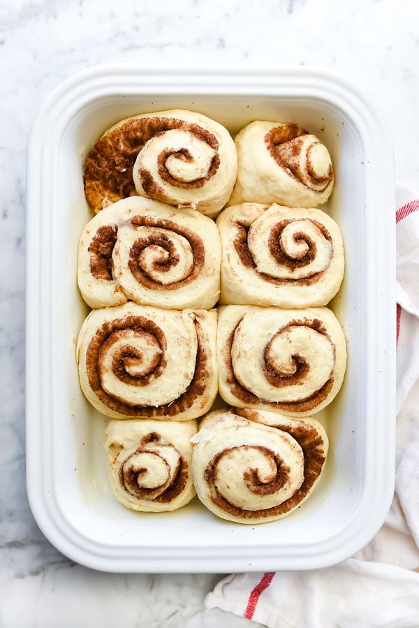 unbaked cinnamon rolls in baking dish after second rise