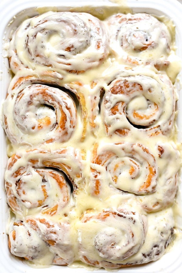 the best cinnamon rolls in white baking dish, slathered with frosting