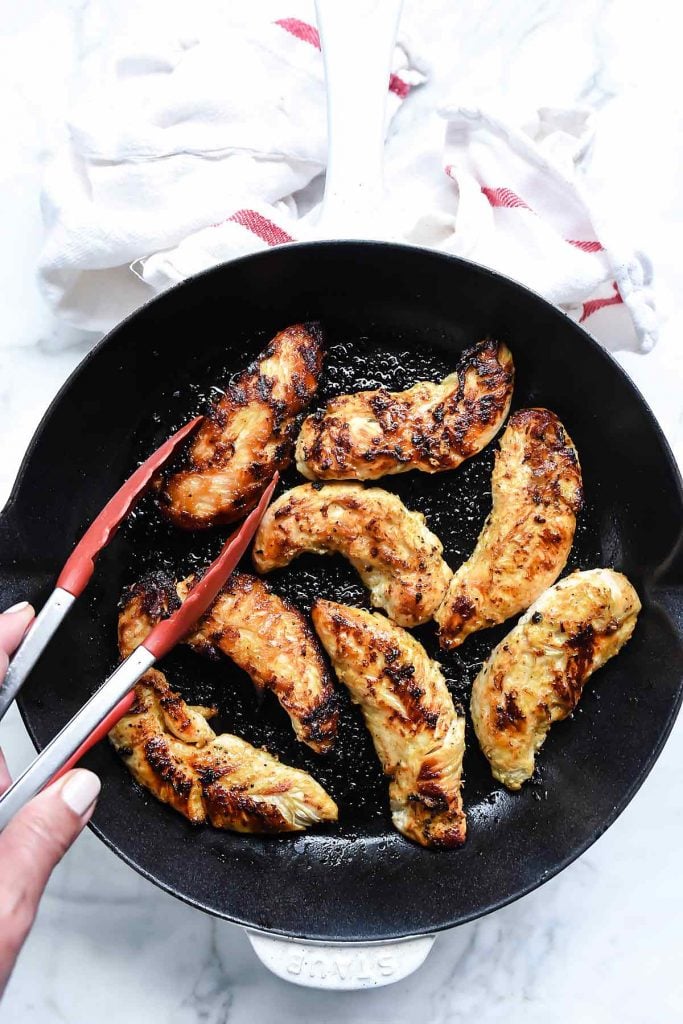 cooking marinated chicken in a skillet for pita gyros