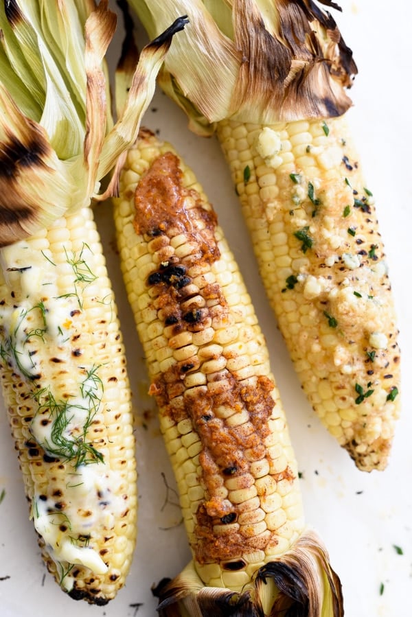 three ears of grilled corn slathered with compound butter