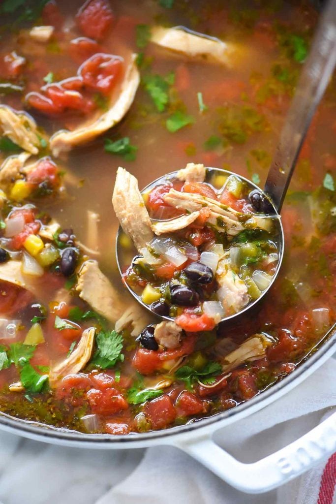 white dutch oven filled with the best chicken tortilla soup