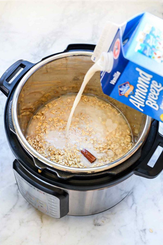 pouring almond milk into pot of oatmeal