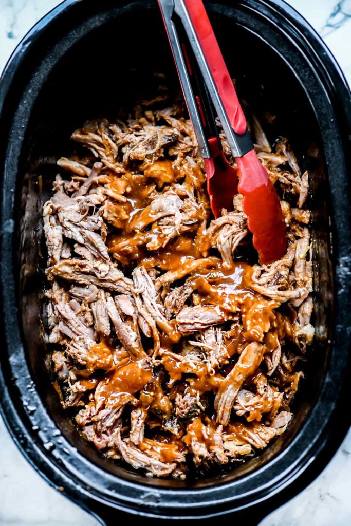 tossing Slow Cooker Pulled Pork with sauce