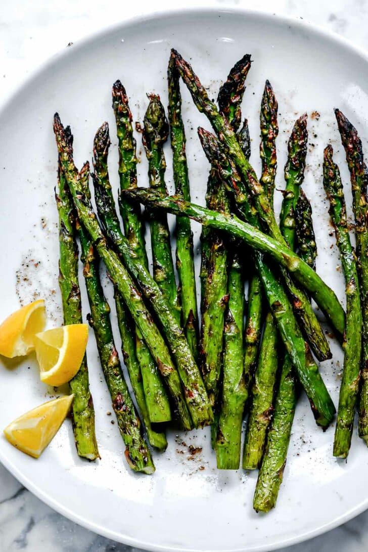 Grilled asparagus on a plate with lemon 
