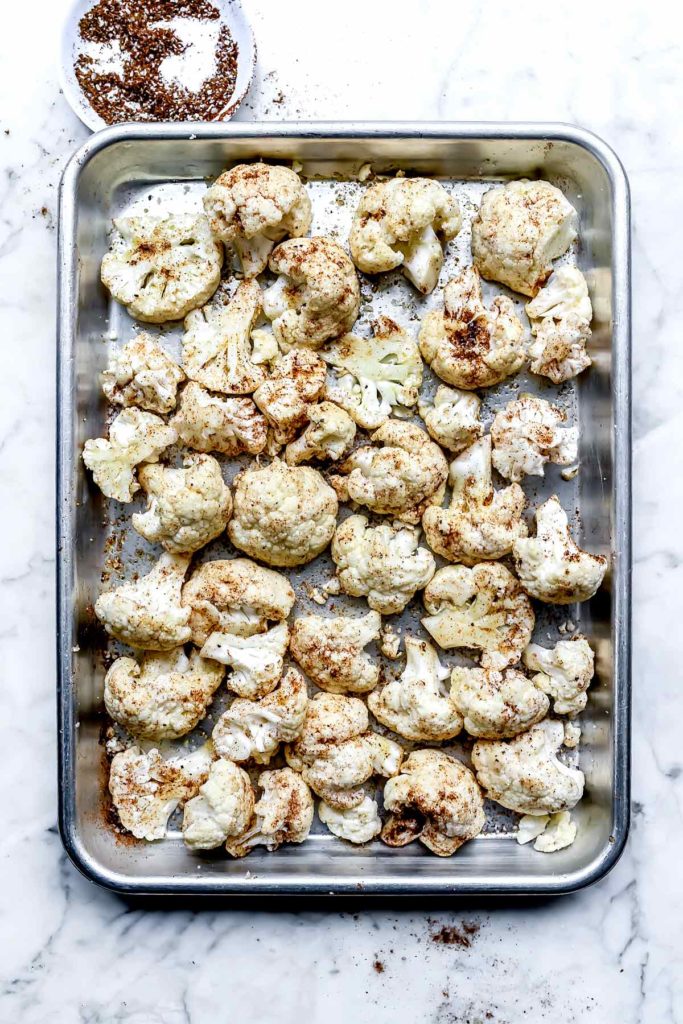 Cauliflower with spice mixture on a baking sheet | foodiecrush.com
