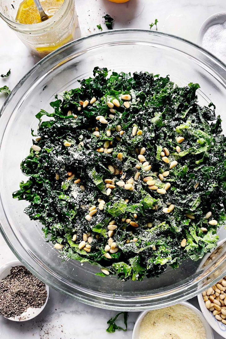 Kale Salad with Parmesan and Pine Nuts in bowl foodiecrush.com