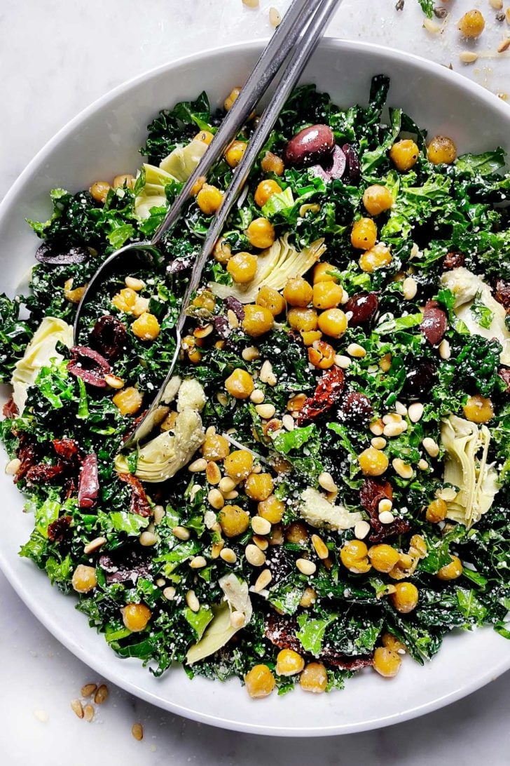 Mediterranean Kale Salad In Bowl with Serving Spoons foodiecrush.com