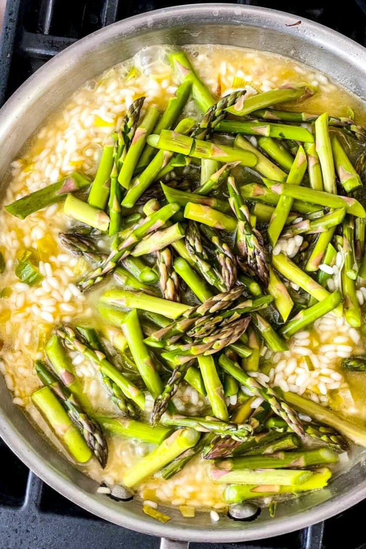 Asparagus Risotto with arborio rice stirring in skillet foodiecrush.com