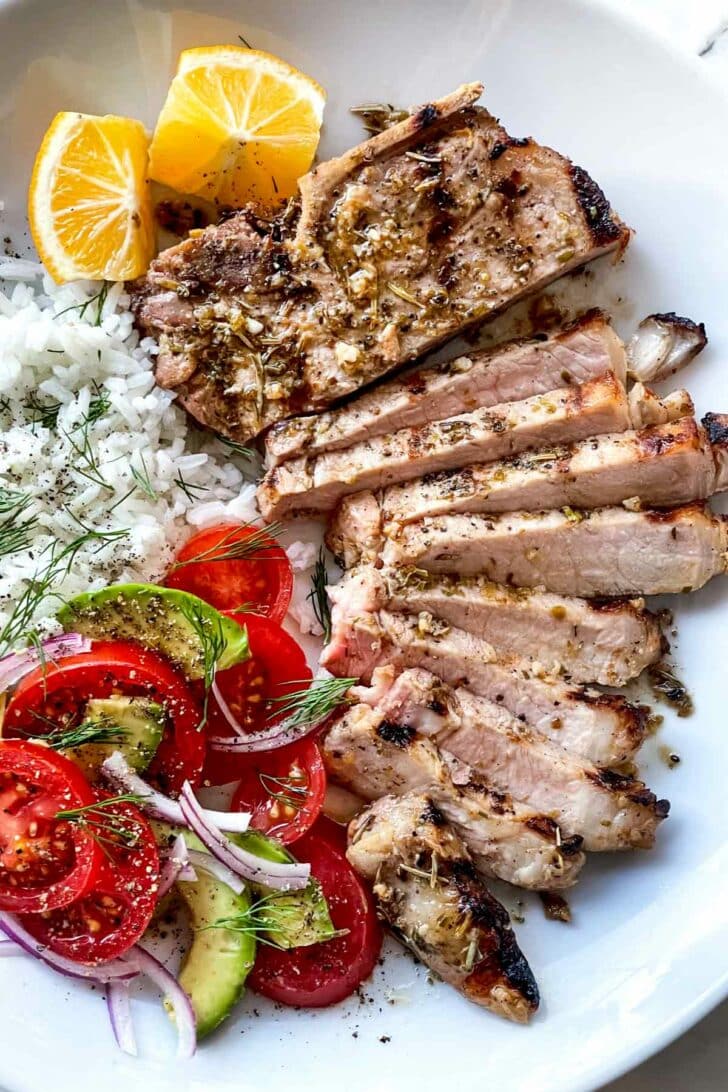 Marinated Pork Chops Greek style sliced on plate foodiecrush.com