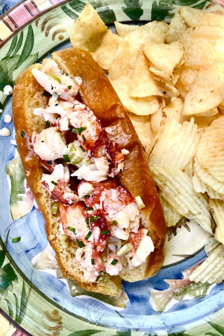 Lobster Roll with potato chips on plate foodiecrush.com