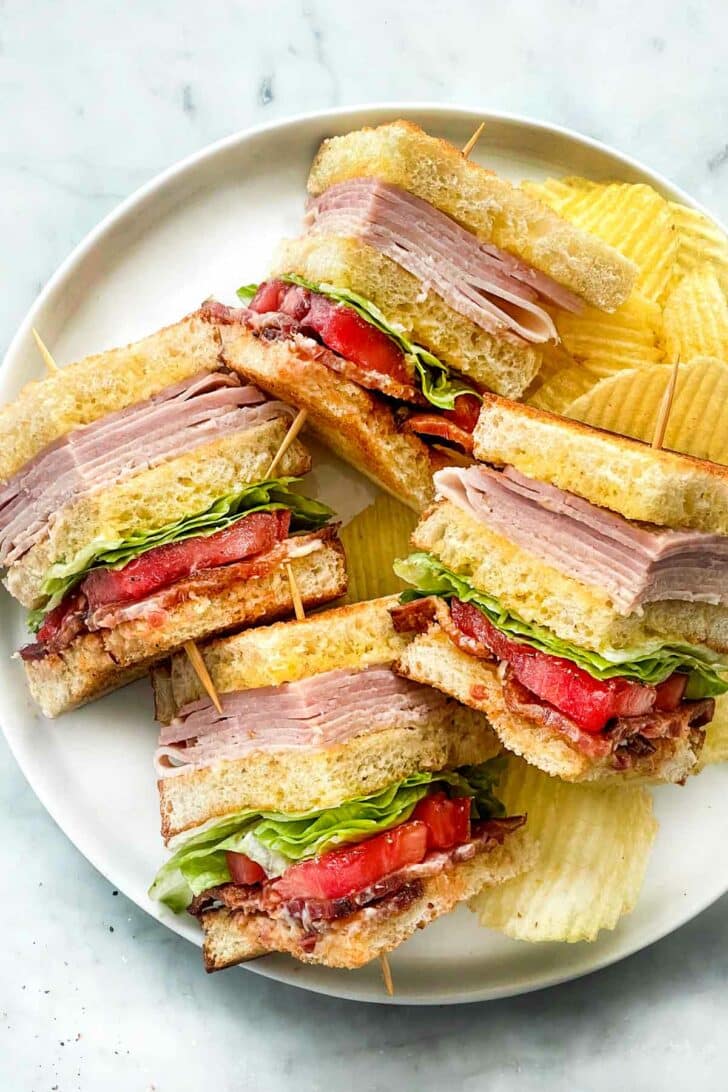 Club Sandwich with toothpicks on plate with potato chips foodiecrush.com