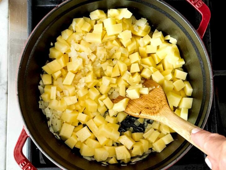 Potatoes and onion in dutch oven on stove for Potato Soup recipe foodiecrush.com