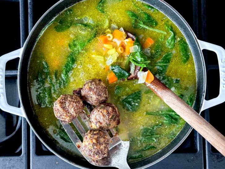 Meatballs and broth with ingredients in dutch oven for Italian Wedding Soup foodiecrush.com