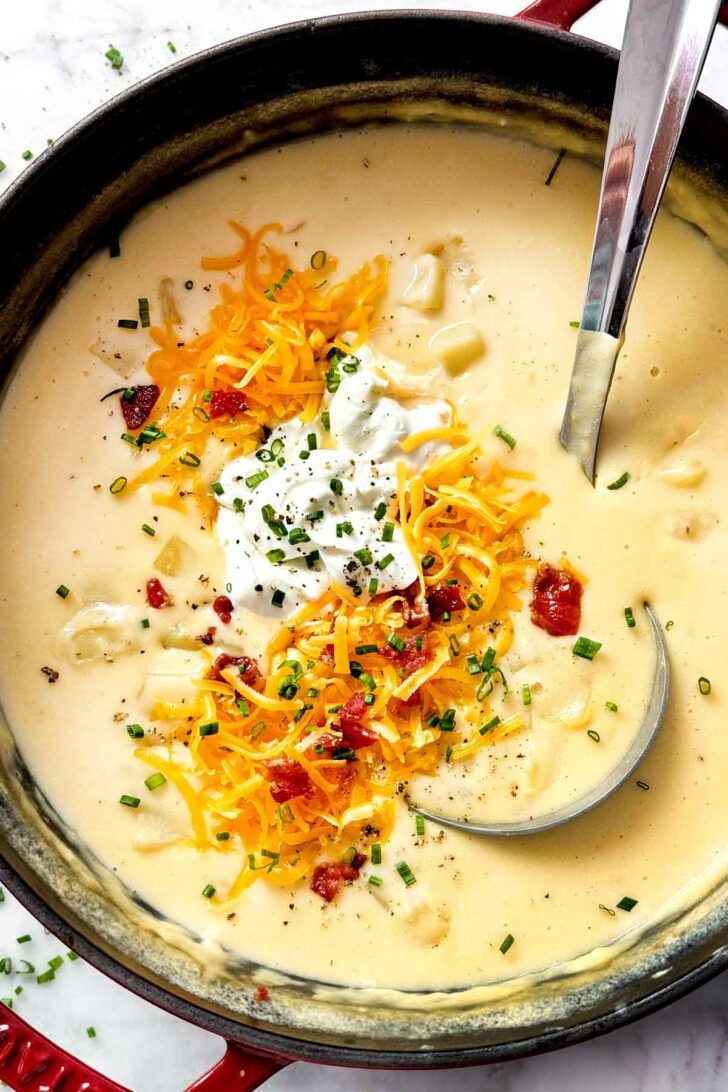 Potato Soup Recipe with bacon, cheese, and sour cream with ladle in pot foodiecrush.com