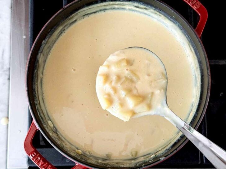 Potato Soup made with evaporated milk in ladle on stove foodiecrush.com