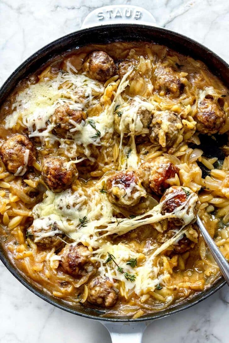 French Onion Meatballs with Orzo in skillet with gruyere cheese foodiecrush.com
