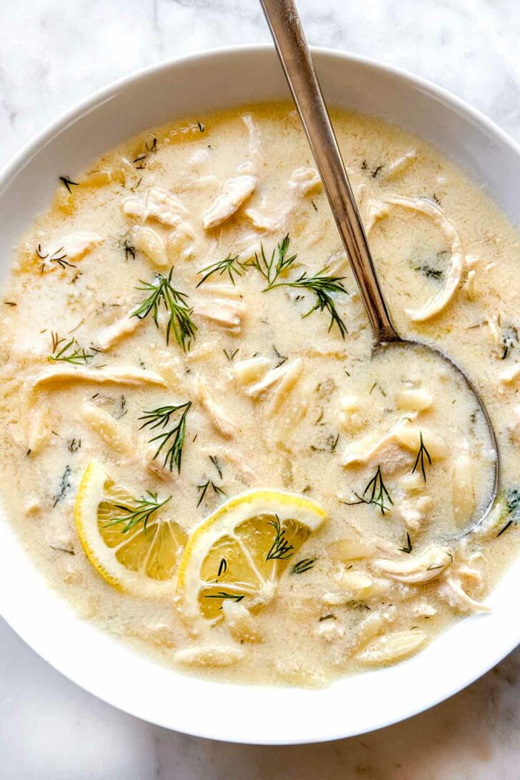 Avogolemono Soup Greek Lemon Chicken Soup with Orzo in bowl with spoon foodiecrush.com