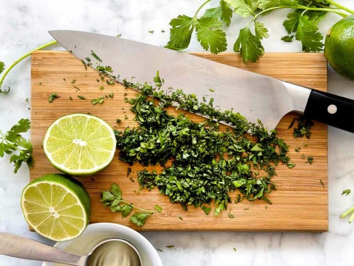Chopped cilantro on cutting board with limes foodiecrush.com
